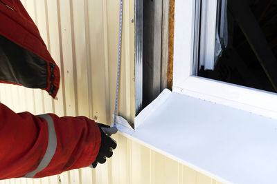 Low section of person standing by window