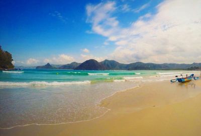 Scenic view of beach against cloudy sky