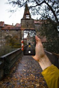 Cropped hand of woman holding mobile phone