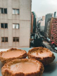 Close-up of bread on table against buildings in city