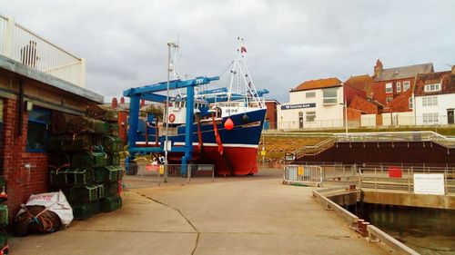 Boats moored on shore against sky