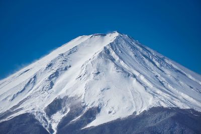 Scenic view of snowcapped mountains against clear blue sky