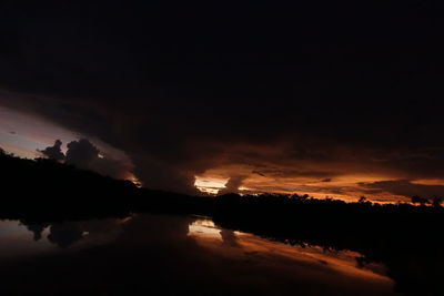 Scenic view of silhouette trees against sky at night