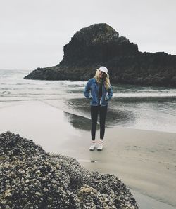 Full length of woman standing on shore at beach