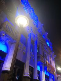 Low angle view of illuminated light against building at night