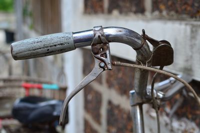 Close-up of bicycle by brick wall