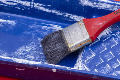 High angle view of paintbrushes on blue container