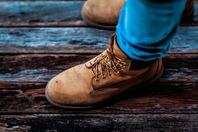 Low section of man wearing brown shoes on boardwalk