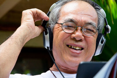 Close-up of smiling man using smart phone