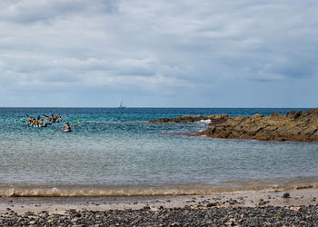 People on beach against sky