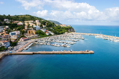 Aerial view of city by sea against sky