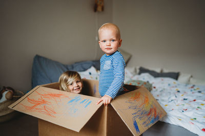 Brothers playing and drawing in a box during lockdown