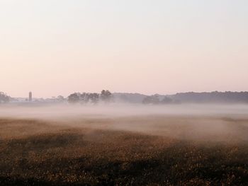 Scenic view of field against sky during foggy weather