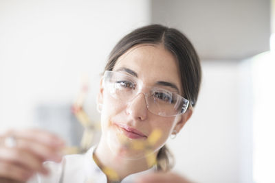 Scientist female with lab glasses, tablet and sample in a lab