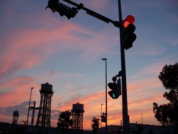 Low angle view of road sign against sky during sunset