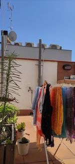 Clothes drying on clothesline by building against clear sky