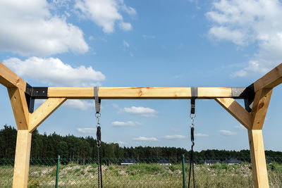 Low angle view of metallic fence against sky