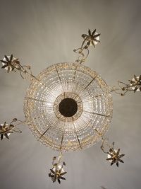 Low angle view of illuminated chandelier hanging on ceiling