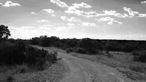 Road by landscape against sky