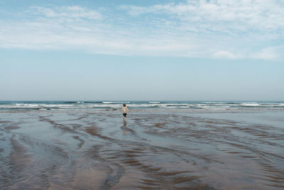 Woman on beach against sky