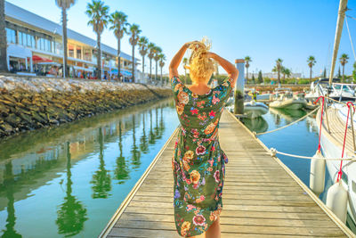 Rear view of woman walking at harbor