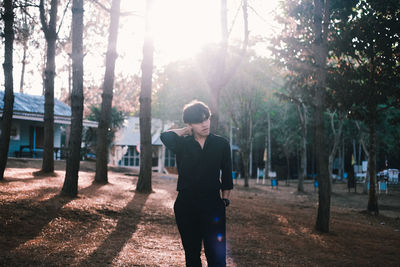 Man standing by tree trunk