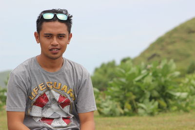 Portrait of young man standing on field