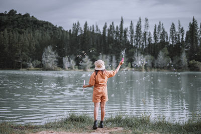 Rear view of woman standing in lake