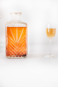 Close-up of glass bottle on table against white background