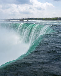 Scenic view of waterfall against sky