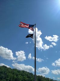 Low angle view of flag against blue sky