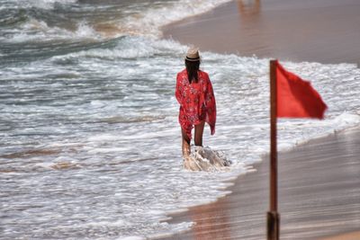 Rear view of man walking in sea