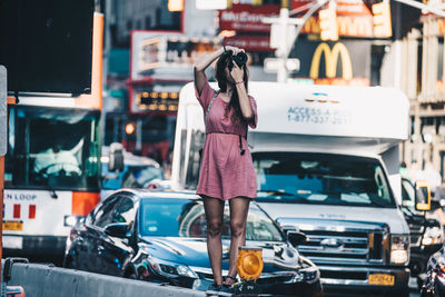 Rear view of woman standing in car