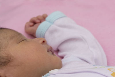 Close-up of baby sleeping on bed