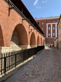 Cobblestone street amidst buildings against sky