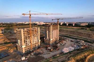 High angle view of crane at construction site against sky