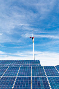 Low angle view of windmill against blue sky