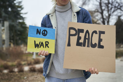 Midsection of woman holding banner