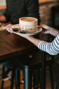 Midsection of woman using mobile phone on table