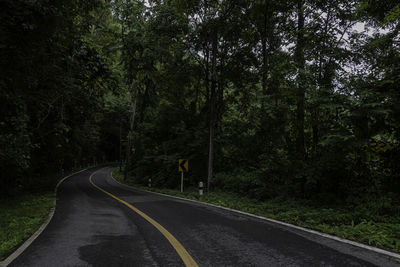 Road amidst trees in forest