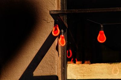 Close-up of red lights hanging on wall