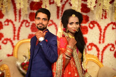 Portrait of newlywed couple gesturing while standing during wedding ceremony