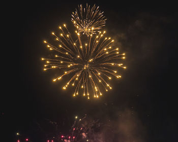 Low angle view of firework display at night