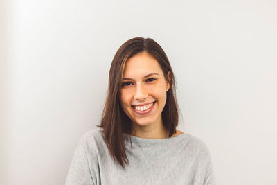 Portrait of young woman against wall