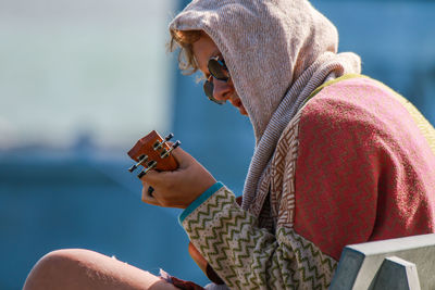 Side view of woman playing guitar
