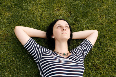 Beautiful young woman lying on grass