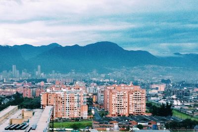 View of cityscape against cloudy sky