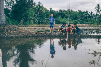 Girl playing on water against trees