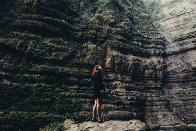 Full length of woman standing against trees