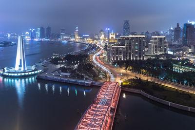 High angle view of illuminated highway amidst buildings at night